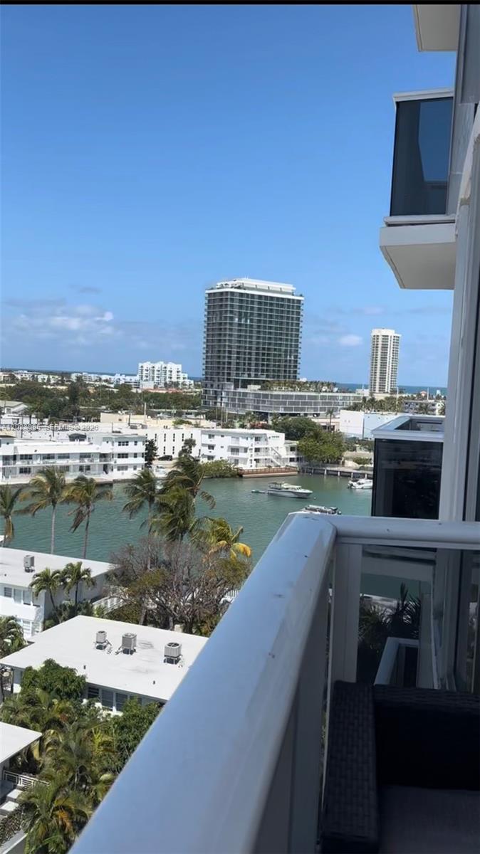 A view from a balcony overlooking a canal, palm trees, and several high-rise buildings — 900 Bay Dr # 811, Miami Beach FL 33141, MIAMI BEACH, FL