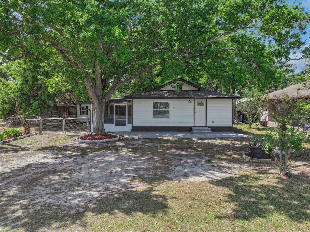 A single-story house with white siding and a large tree in the front yard — 232 NOXON STREET, AUBURNDALE, FL