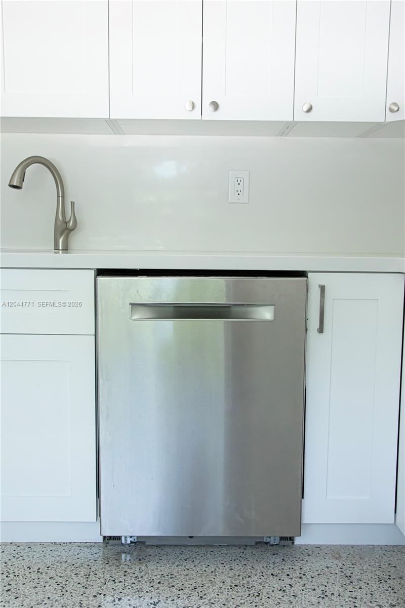 A stainless steel dishwasher is installed between white cabinets under a white countertop — 1226 SW 30th Ave # 1226, Miami FL 33135, MIAMI, FL
