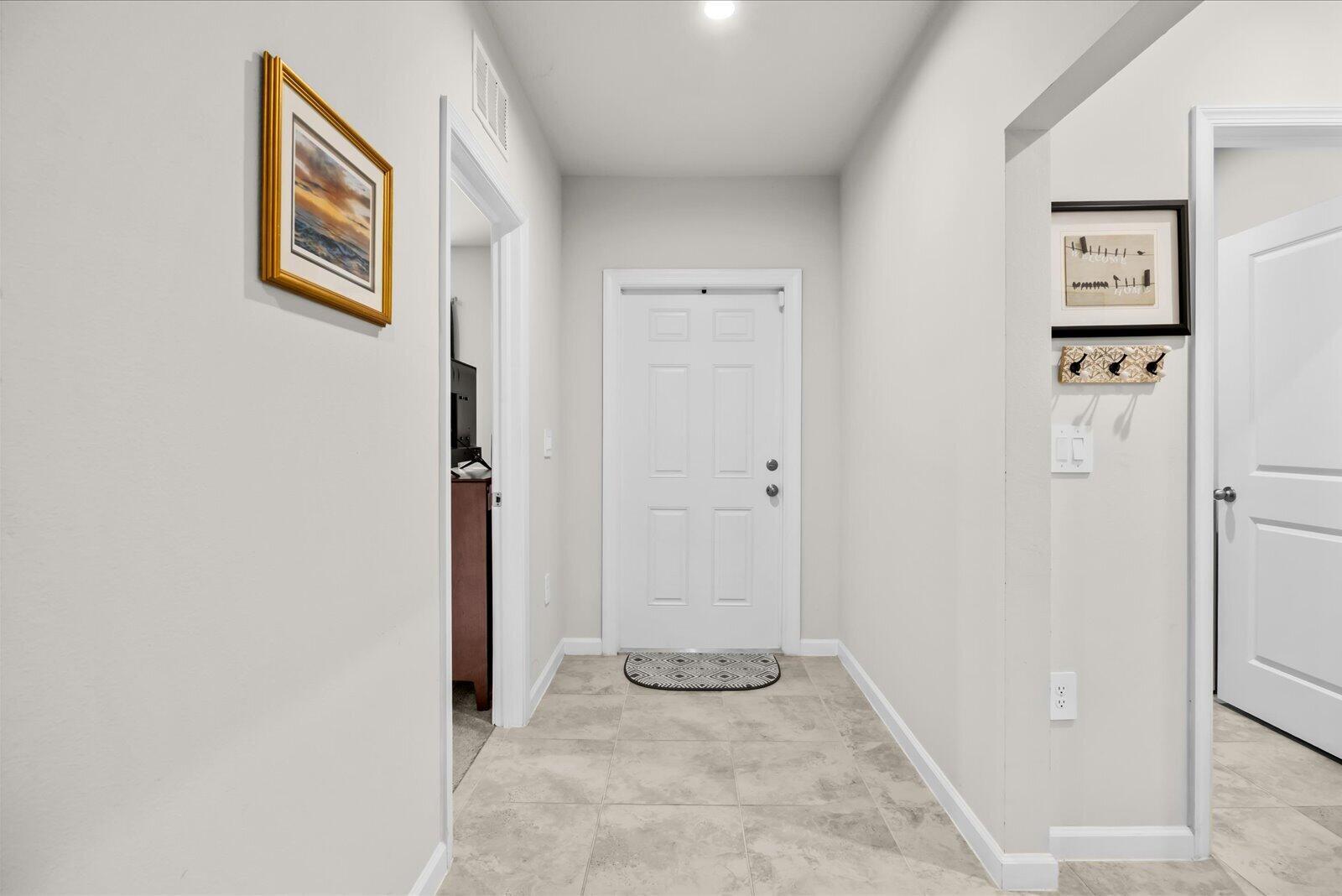 A bright entryway features light tile flooring, a white front door, and neutral wall paint — 843 Persimmon Place, Fort Pierce FL 34981, FORT PIERCE, FL