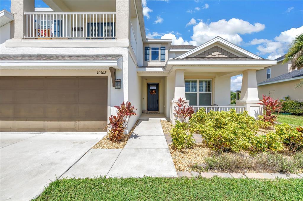 A two-story suburban house features a garage, a front porch, and a second-floor balcony — 10108 CORRIENTE COURT, PALMETTO, FL