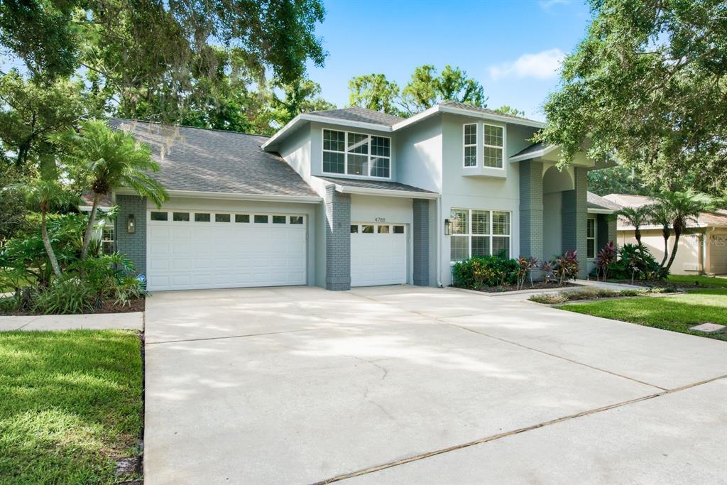 A two-story house with a gray exterior, brick accents, and a three-car garage — 4788 BRAYTON TERRACE S, PALM HARBOR, FL