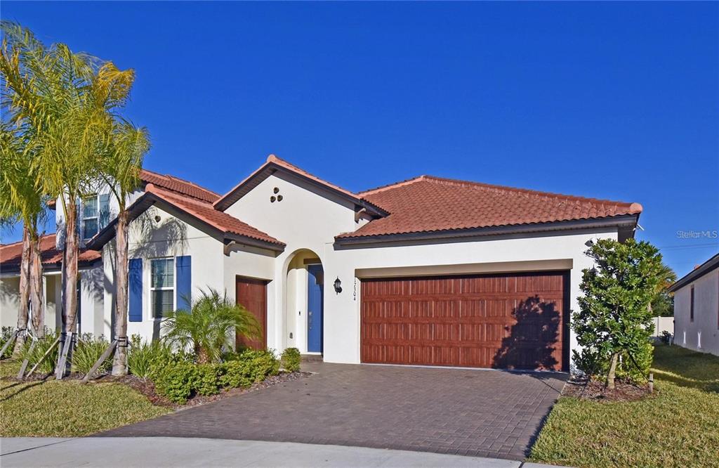 A single-story house with a tile roof, stucco exterior, and a two-car garage — 17304 BANDED GOLD LANE, WIMAUMA, FL