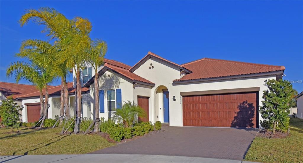 A single-story house with a tiled roof, stucco exterior, and a three-car garage — 17304 BANDED GOLD LANE, WIMAUMA, FL