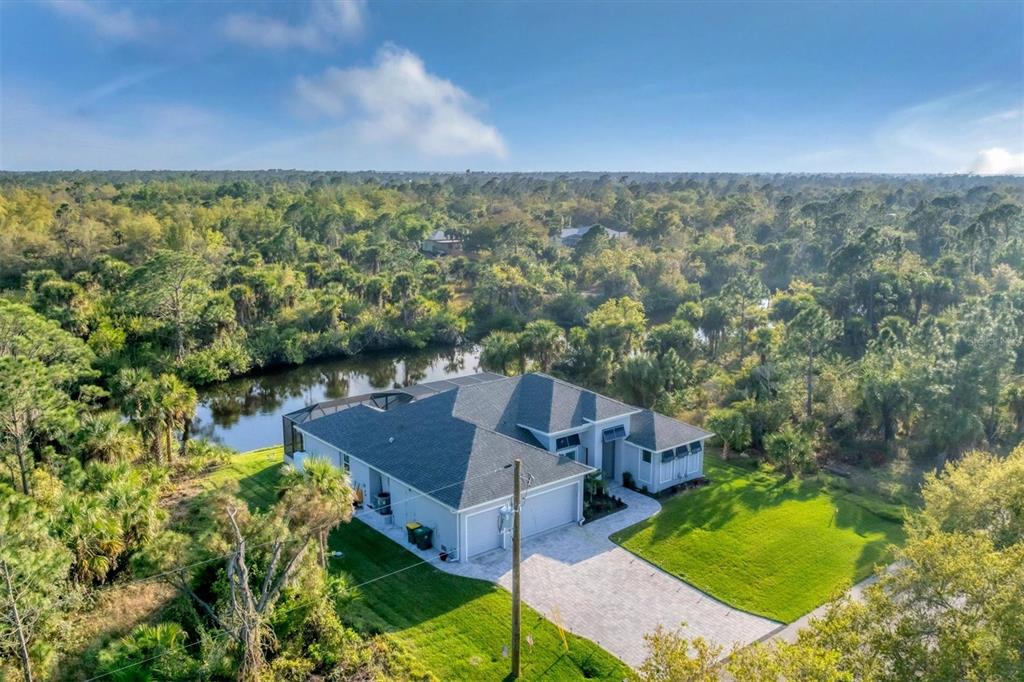 An aerial view of a single-story house with a gray roof, pool cage, and driveway — 14351 HOWARD AVE, PORT CHARLOTTE, FL