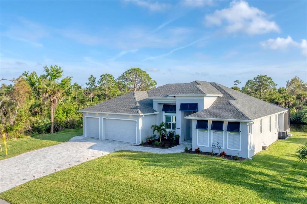 A single-story house with a gray roof, light exterior, and a three-car garage — 14351 HOWARD AVE, PORT CHARLOTTE, FL