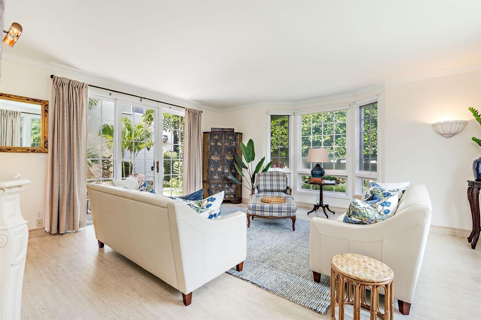 A dining room features a glass-topped rattan table, four white chairs, and parrot wall art — 155 Peruvian Avenue, Palm Beach FL 33480, PALM BEACH, FL