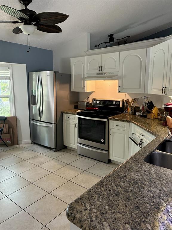 A kitchen features white cabinets, stainless steel appliances, and granite countertops over tiled floors — 849 HAPPINESS AVENUE SW, PALM BAY, FL