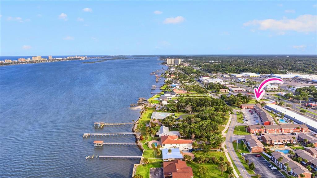 An aerial view shows a waterfront residential complex with docks extending into the river — 2250 S PALMETTO AVENUE UNIT J-5, SOUTH DAYTONA, FL