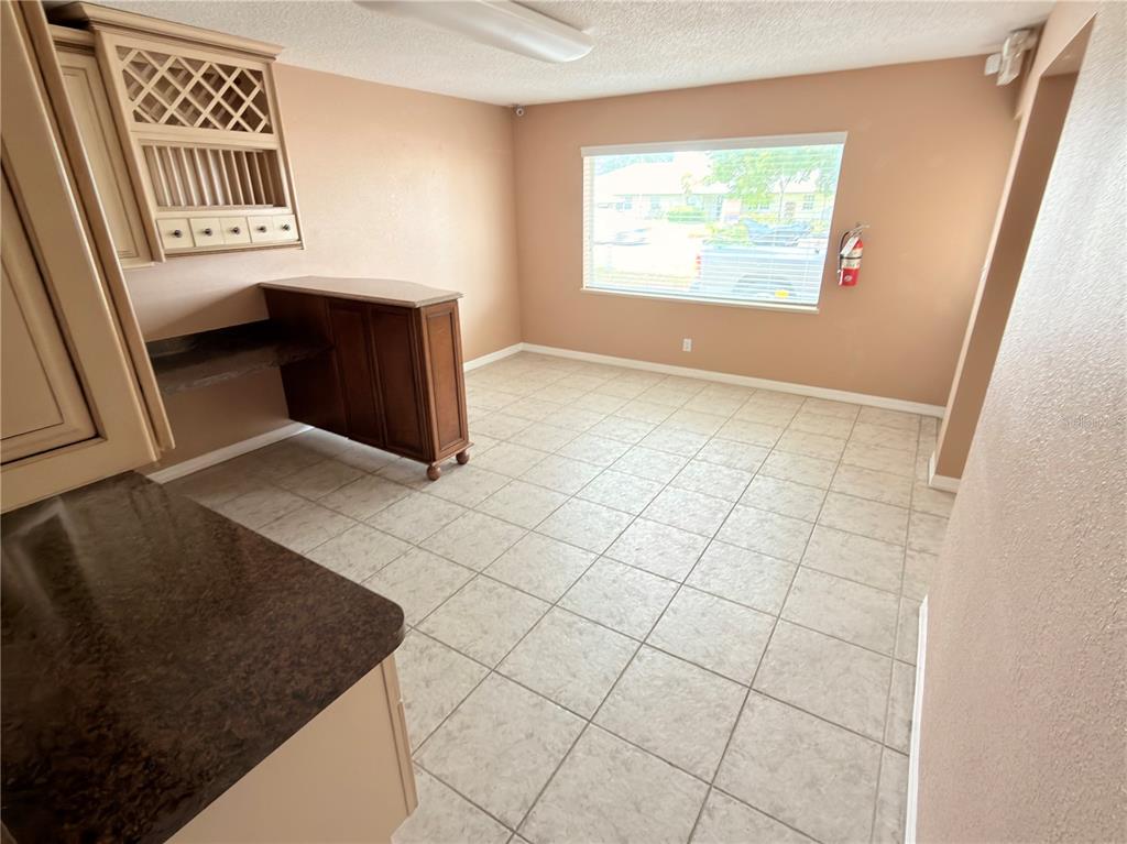 A kitchen area features tile flooring, a built-in wine rack, and a dark wood bar — 2914-A KENILWORTH BOULEVARD, SEBRING, FL