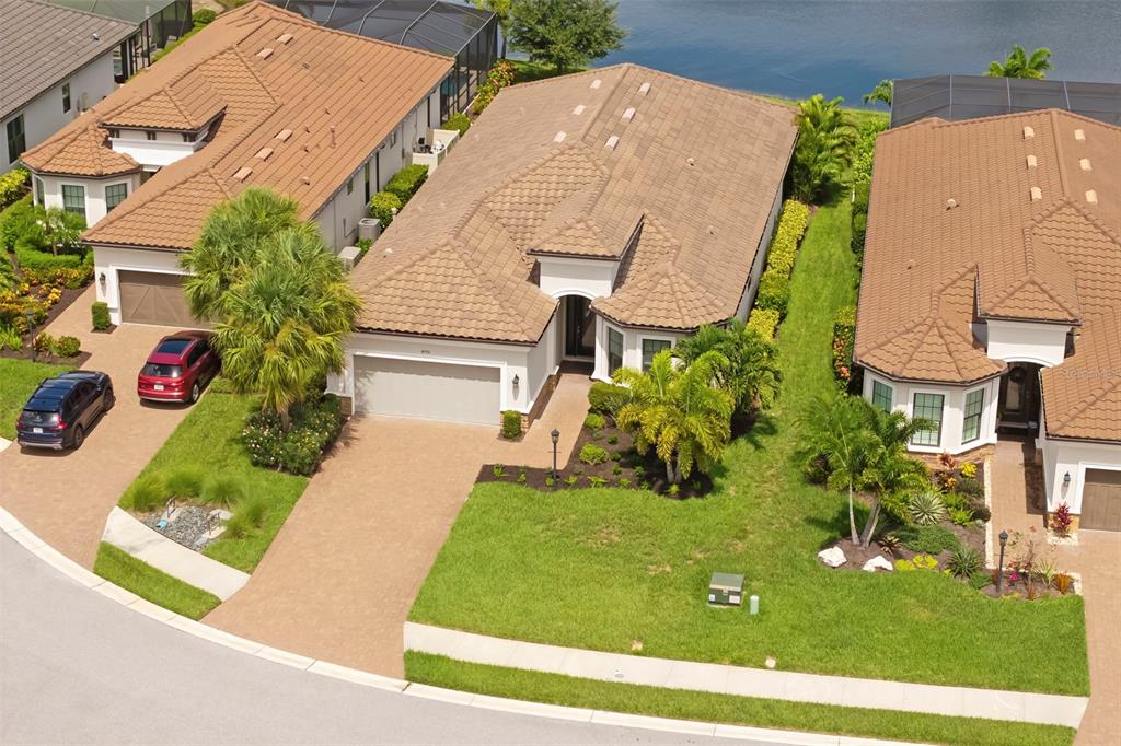 An aerial view shows a suburban house with a tiled roof and a paved driveway — 4730 SARCA COURT, BRADENTON, FL