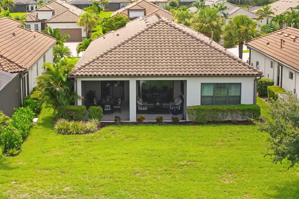 An aerial view of a house with a tiled roof and a covered back patio — 4730 SARCA COURT, BRADENTON, FL