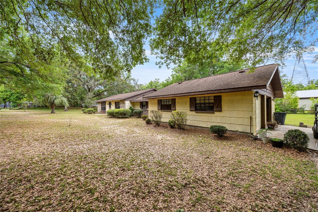 A single-story house with yellow siding and a brown roof sits on a grassy lot — 12882 SE 78TH TERRACE, SUMMERFIELD, FL