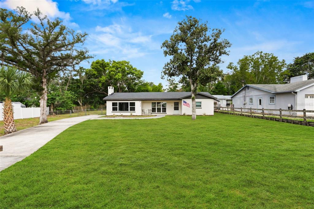 A single-story house with a white exterior, dark roof, and a large front lawn — 508 OHIO BOULEVARD, EUSTIS, FL