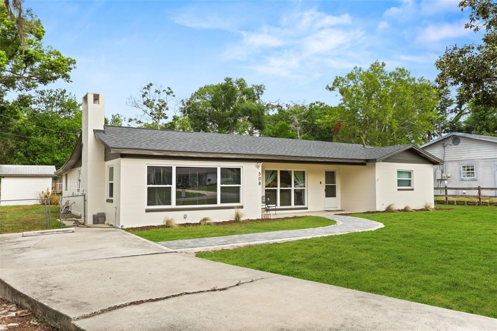 A single-story house with a white exterior, gray roof, and a concrete driveway — 508 OHIO BOULEVARD, EUSTIS, FL