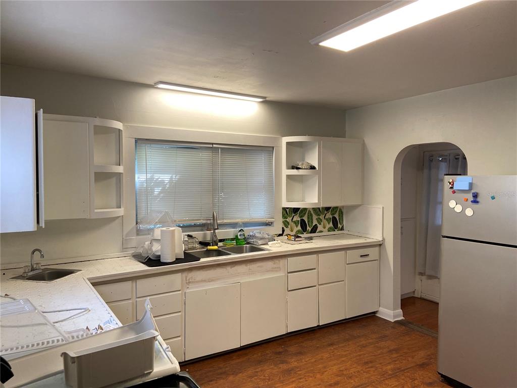 A kitchen features white cabinets, laminate countertops, a double sink, and a refrigerator — 108 S WILLOW AVENUE, TAMPA, FL