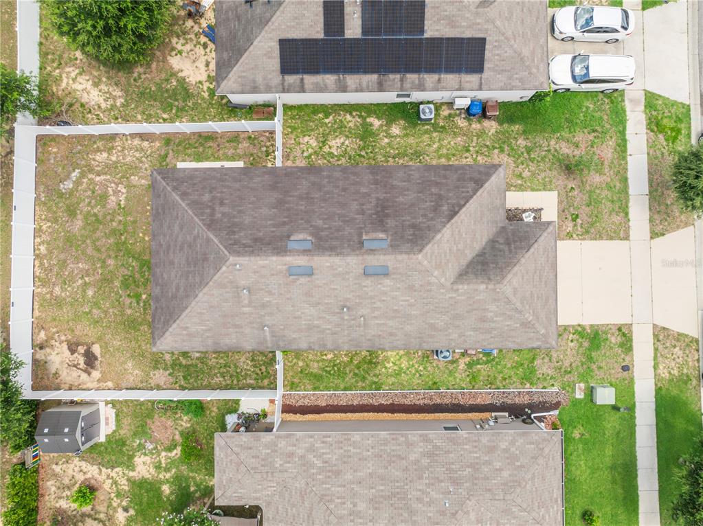An aerial view shows a residential house with a fenced backyard and a storage shed — 125 TANAGER STREET, HAINES CITY, FL