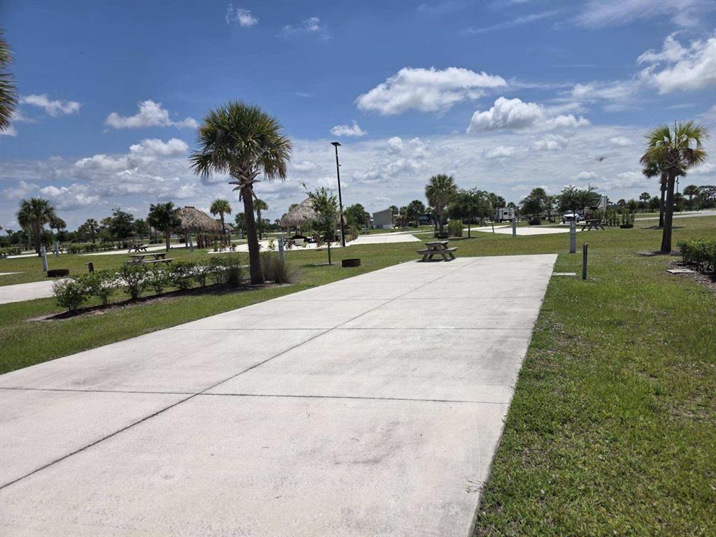 A concrete RV pad sits in a grassy park with palm trees and picnic tables — HIGHWAY 630  E UNIT 44, LAKE WALES, FL