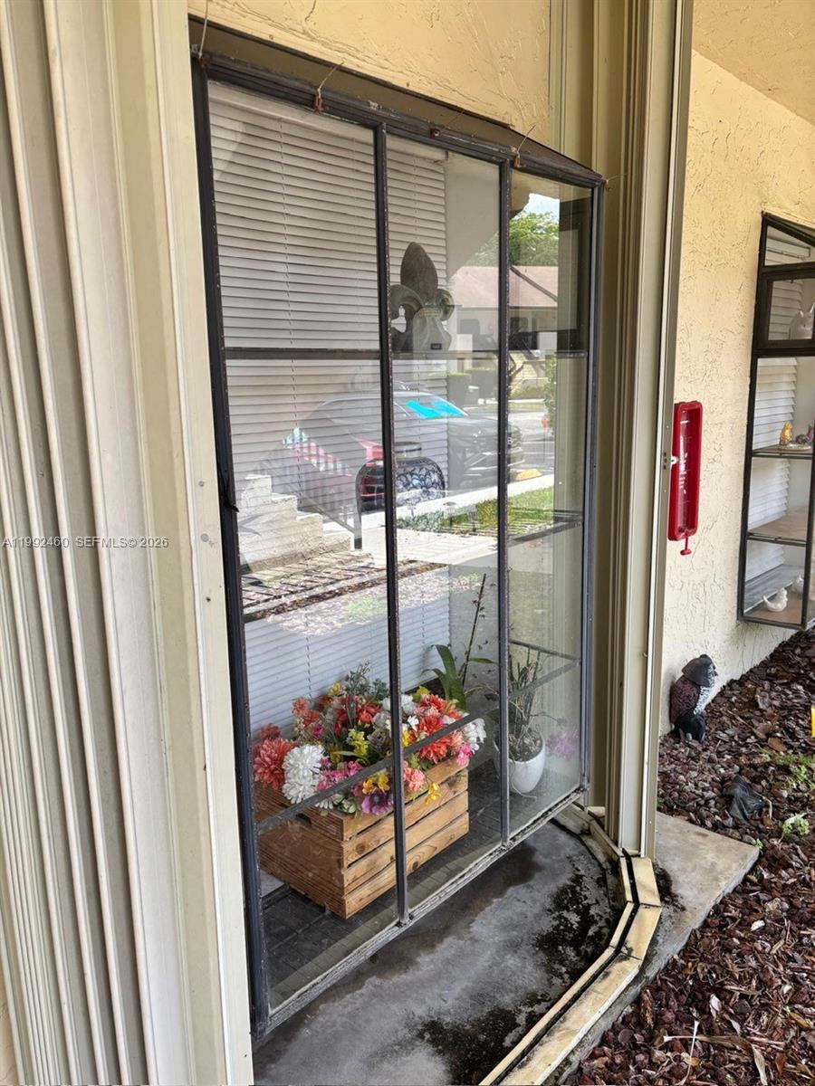 A glass-enclosed exterior display case sits on a concrete patio next to a building — 1969 SW 15th St # 93, Deerfield Beach FL 33442, DEERFIELD BEACH, FL