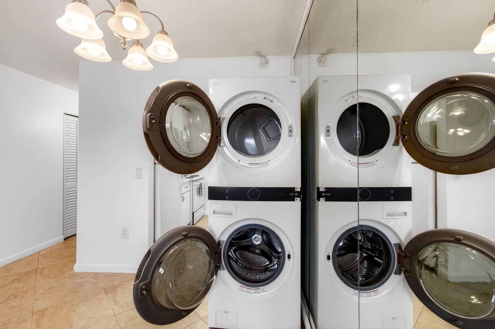 A laundry room features a stacked white LG washer and dryer unit with open doors — 600 SW 2nd Avenue # 240, Boca Raton FL 33432, BOCA RATON, FL