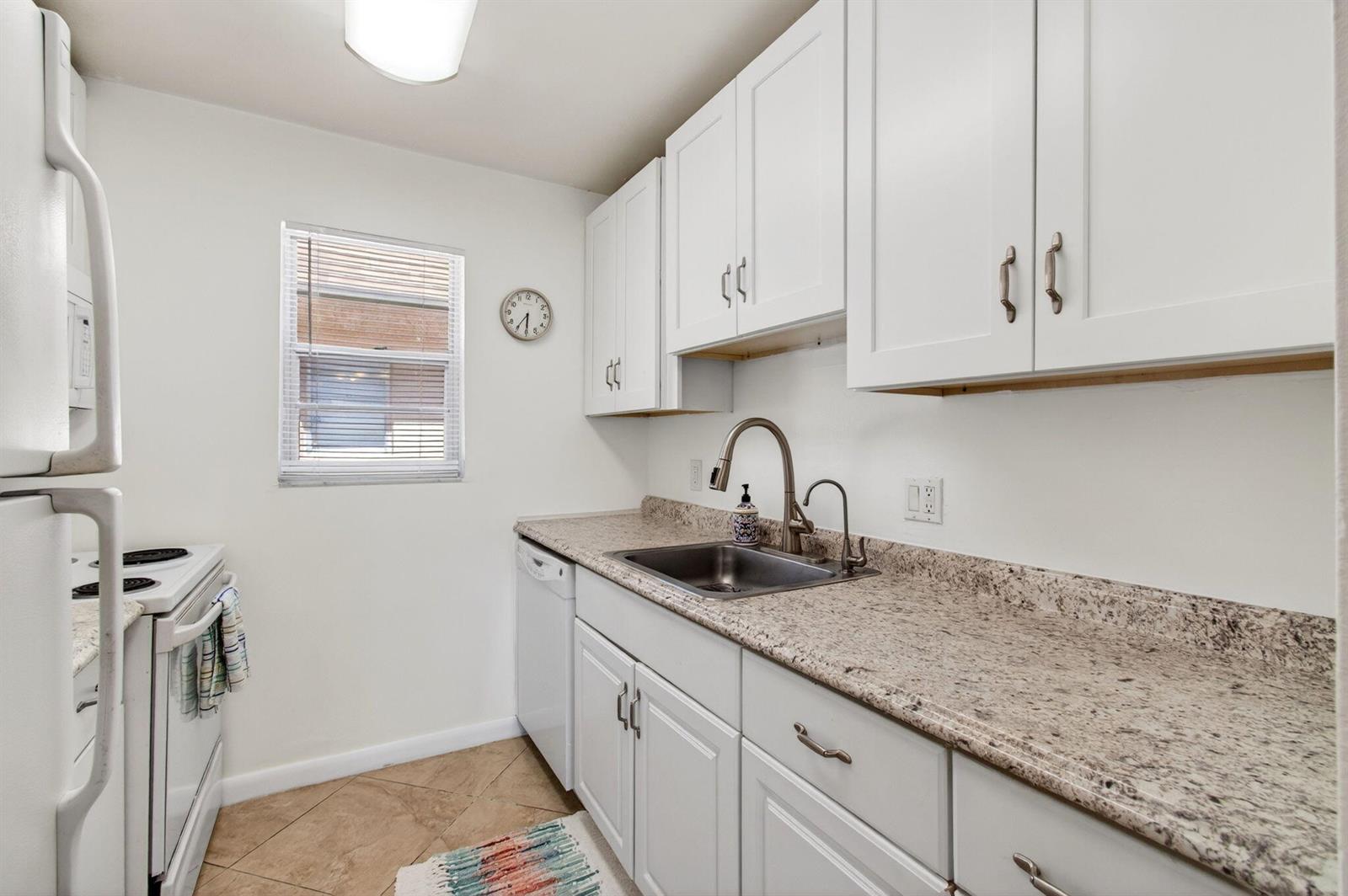 A kitchen with white cabinets, granite countertops, a stainless steel sink, and white appliances — 600 SW 2nd Avenue # 240, Boca Raton FL 33432, BOCA RATON, FL