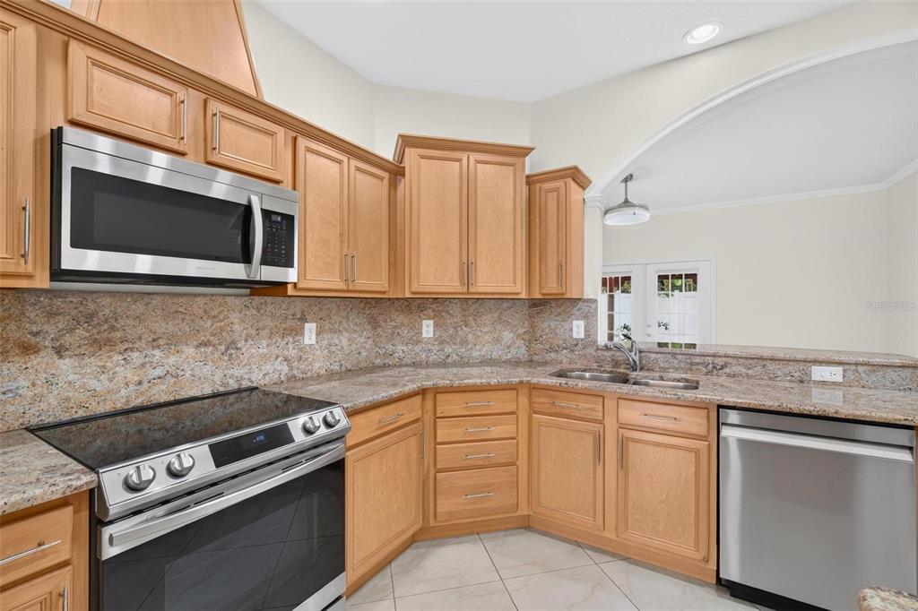 A kitchen with light wood cabinets, granite countertops, and stainless steel appliances — 6026 113TH AVENUE N, PINELLAS PARK, FL