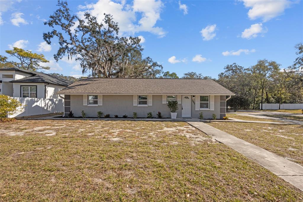 A single-story gray house with a shingled roof sits on a grassy lot — 1682 WILMAR AVENUE, TARPON SPRINGS, FL