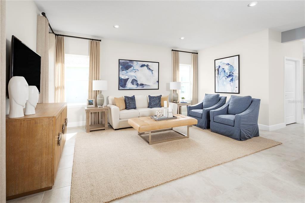 A living room features a white sofa, two blue armchairs, and a tan ottoman — 2437 WHITE LADYFISH ROAD, WIMAUMA, FL