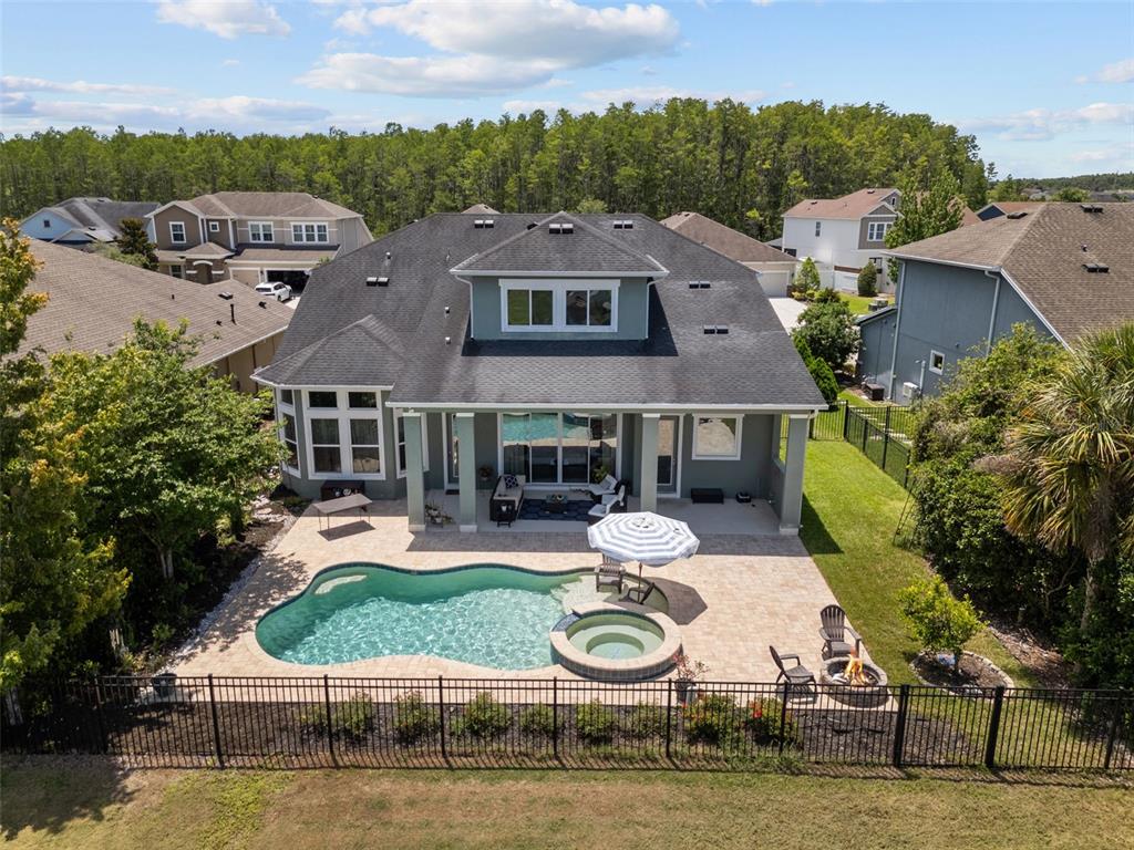 An aerial view of a house backyard featuring a swimming pool, spa, and paved patio — 2903 LONG BOW WAY, ODESSA, FL
