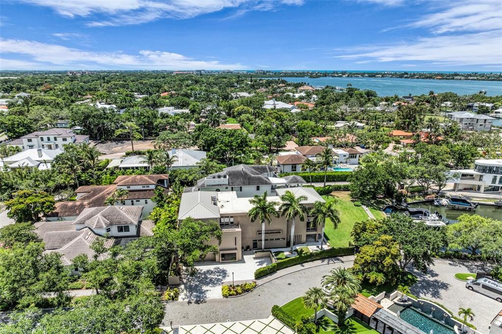 A modern white multi-story house with a large driveway and palm trees at dusk — 1404 KENILWORTH STREET, SARASOTA, FL