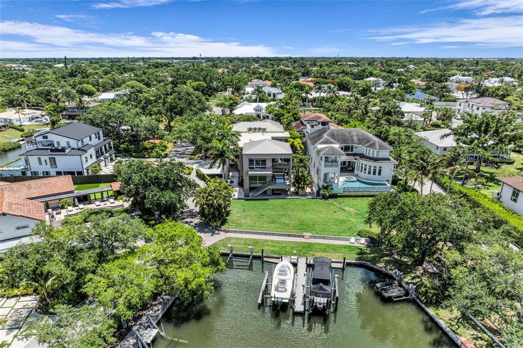 A modern multi-story house with a concrete driveway, garage, and palm trees at dusk — 1404 KENILWORTH STREET, SARASOTA, FL