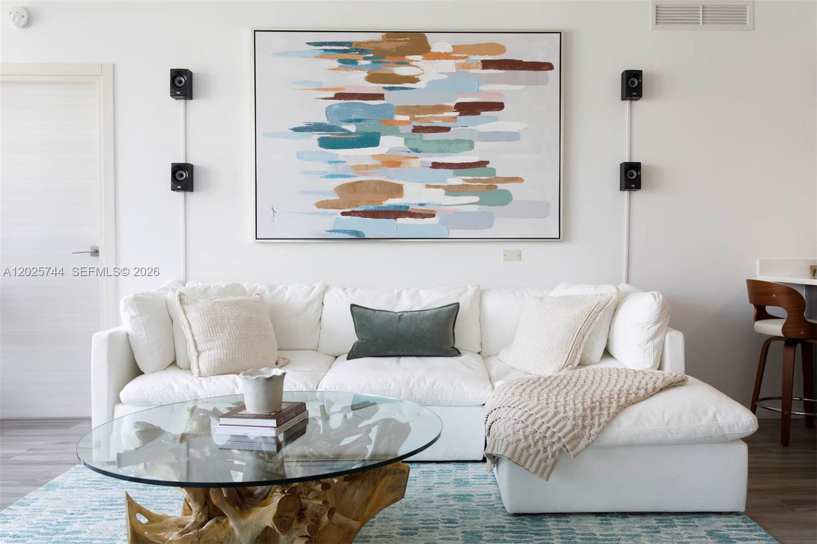 A modern open-concept living and dining area features a white sectional, kitchen island, and wood flooring — 801 S Miami Ave # 2004, Miami FL 33130, MIAMI, FL