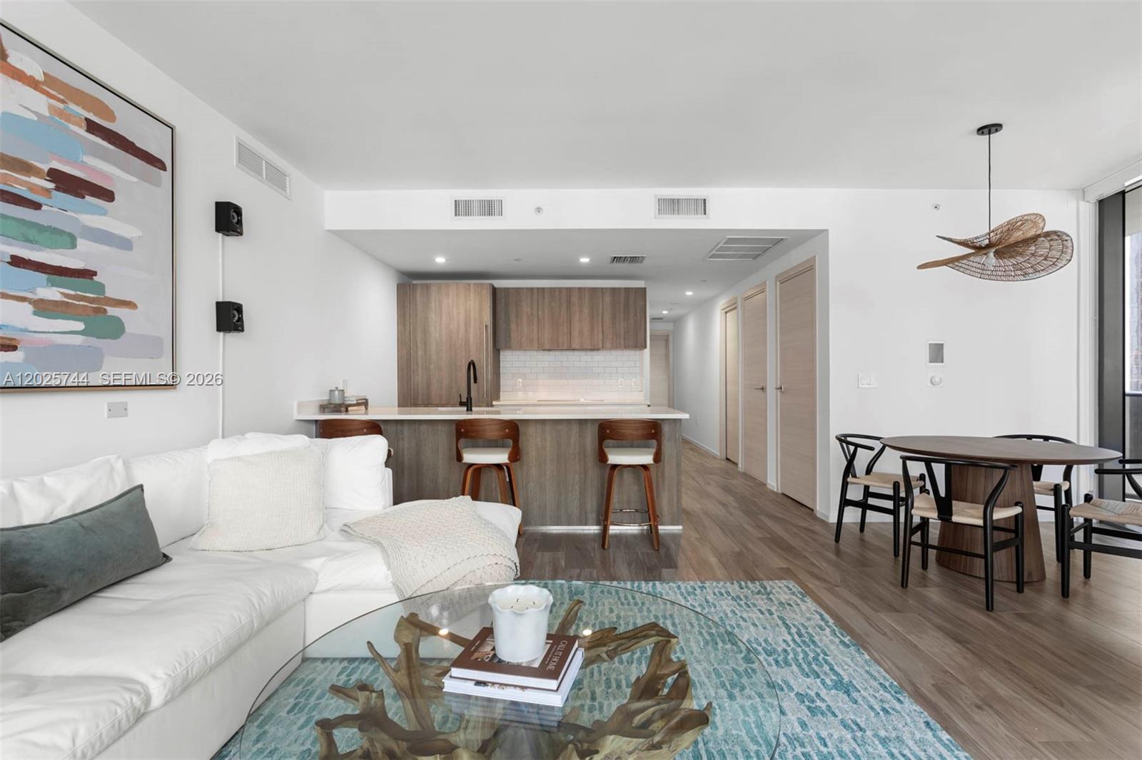 A dining area features a round wooden table, black chairs, and a large pendant light — 801 S Miami Ave # 2004, Miami FL 33130, MIAMI, FL