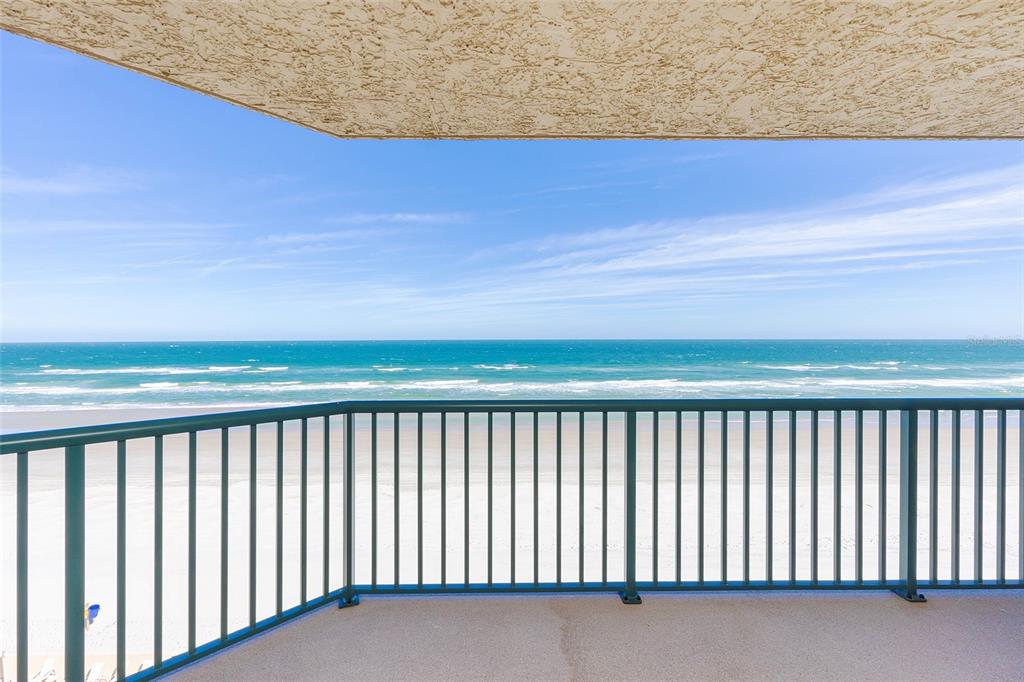 A balcony with a dark metal railing overlooks a sandy beach and the ocean — 4631 S ATLANTIC AVENUE UNIT 8601, PONCE INLET, FL