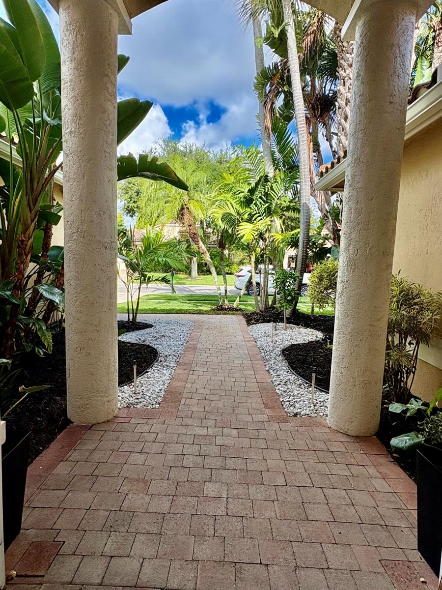 A paved walkway leads through two large columns toward a landscaped front yard — 8958 Terni Lane, Boynton Beach FL 33472, BOYNTON BEACH, FL