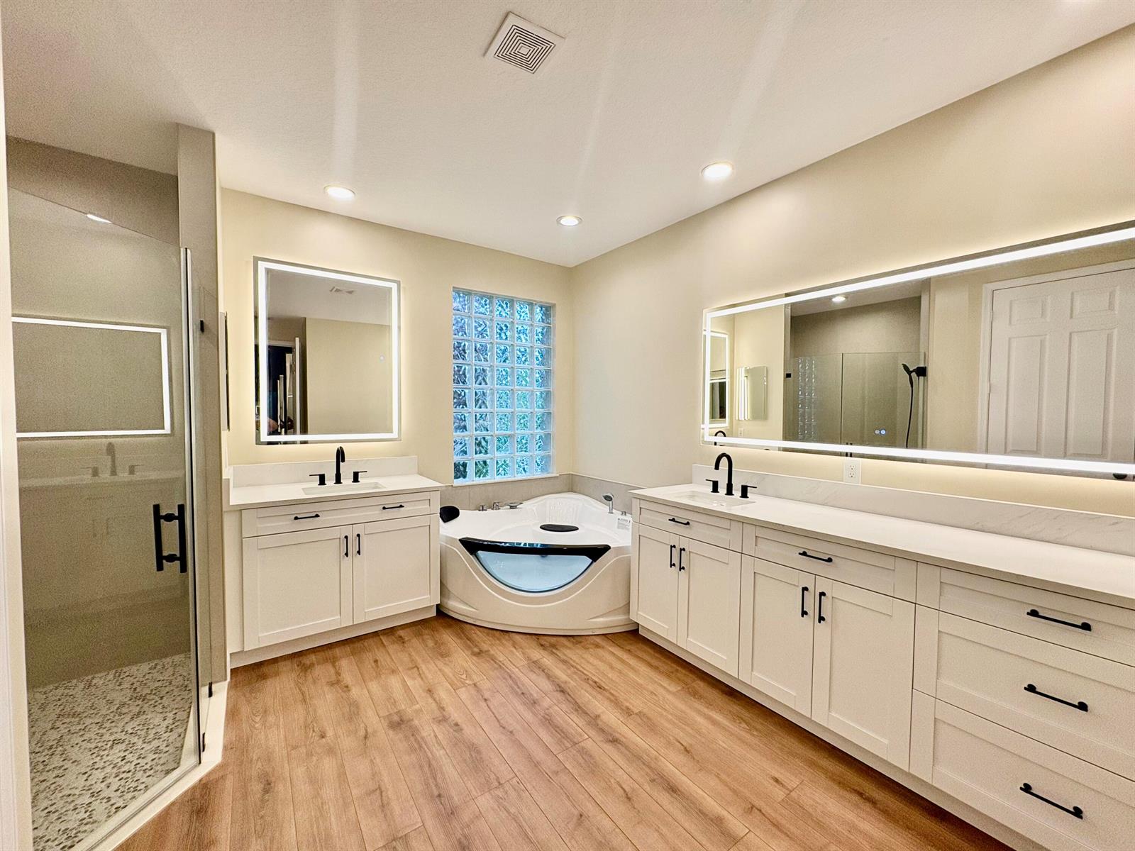 A modern bathroom features dual white vanities, a corner jetted tub, and a glass shower — 8958 Terni Lane, Boynton Beach FL 33472, BOYNTON BEACH, FL