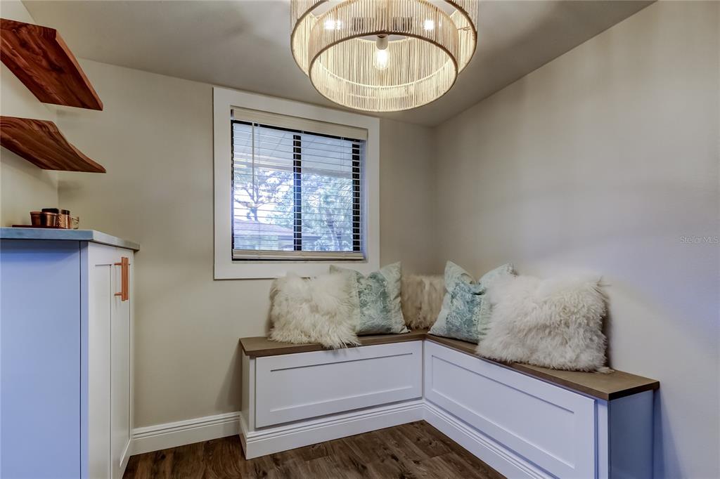 A kitchen features white cabinetry, stainless steel appliances, and a green-veined stone countertop island — 2673 SABAL SPRINGS CIRCLE UNIT 201, CLEARWATER, FL