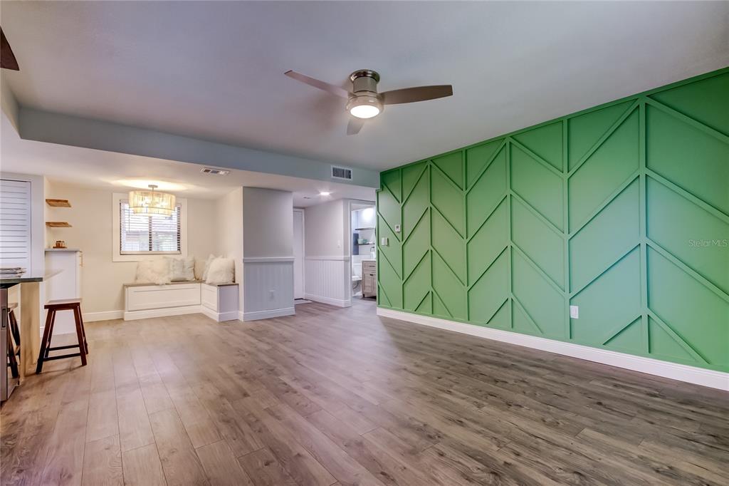 A breakfast nook features a corner built-in bench, a window, and a drum pendant light — 2673 SABAL SPRINGS CIRCLE UNIT 201, CLEARWATER, FL