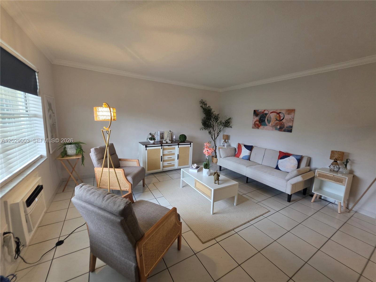 A living room features light-colored tile flooring, a sofa, two armchairs, and a white sideboard — 17000 NE 14th Ave # 109, Miami FL 33162, MIAMI, FL