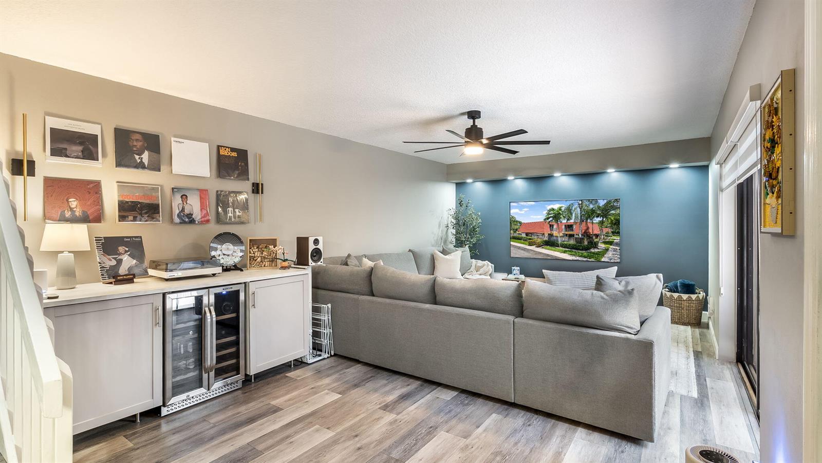 A living room features a grey sectional sofa, a beverage cooler, and a blue accent wall — 725 NW 99th Circle, Plantation FL 33324, PLANTATION, FL