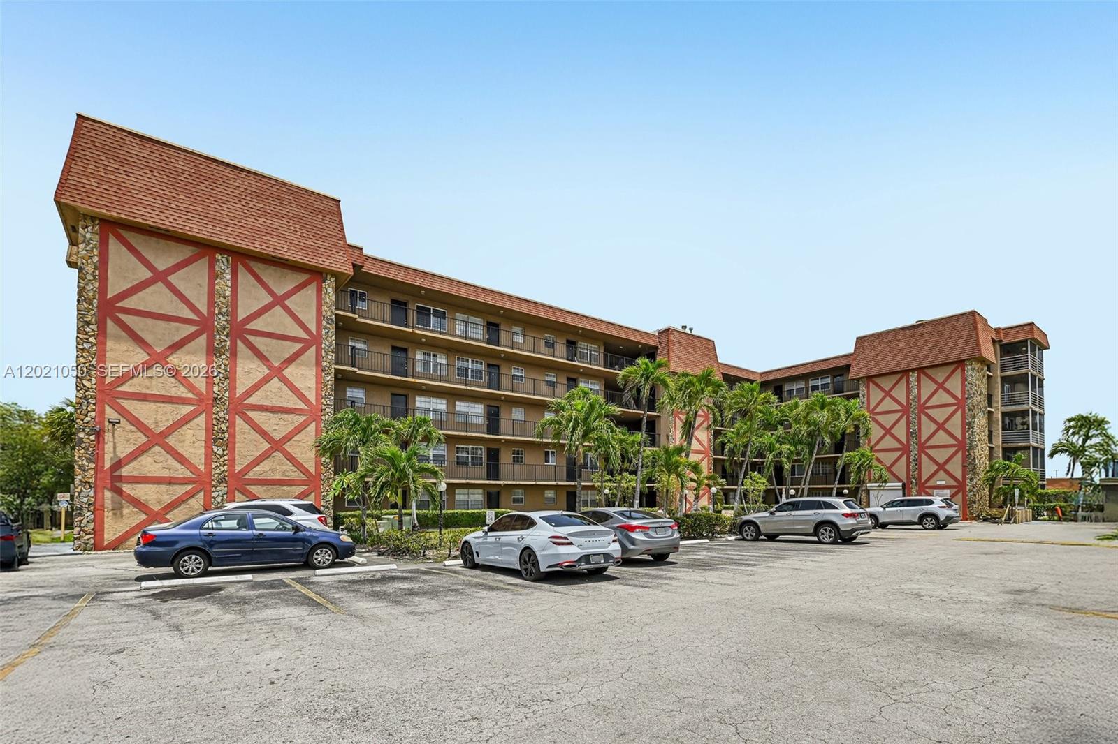 A multi-story apartment building with a parking lot in the foreground under a clear sky — 6575 W 4th Ave # 507, Hialeah FL 33012, HIALEAH, FL