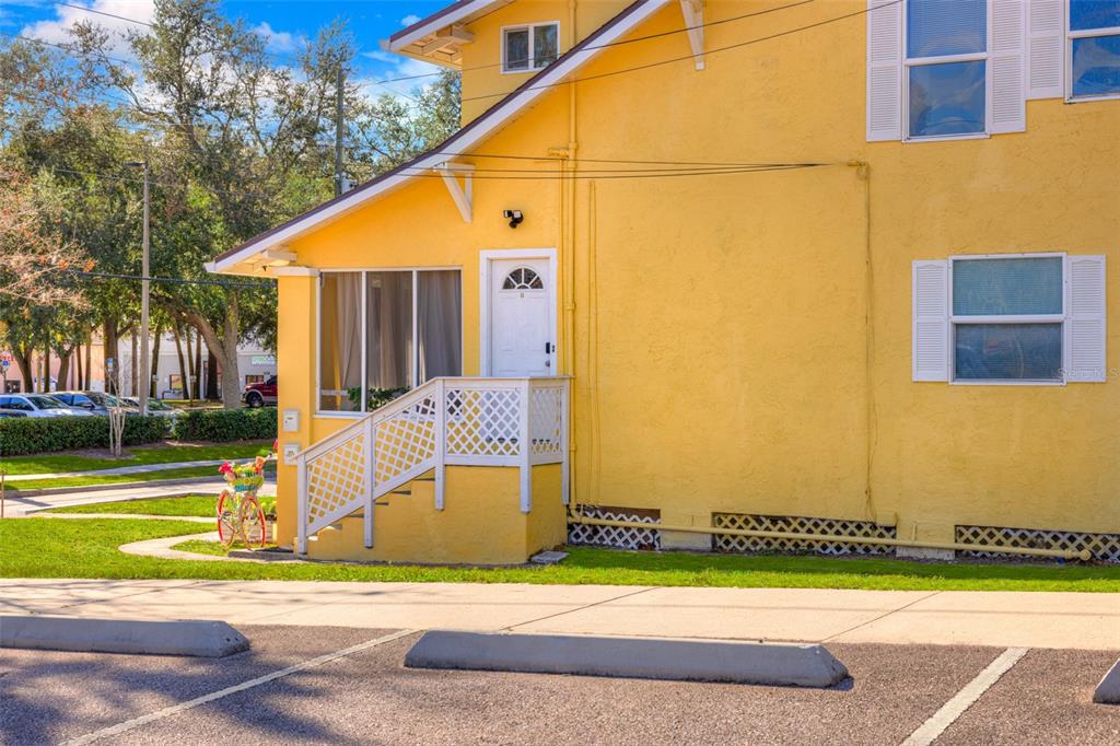 A yellow two-story building features a white front door, a small porch, and lattice skirting — 117 E EUCLID AVENUE, DELAND, FL