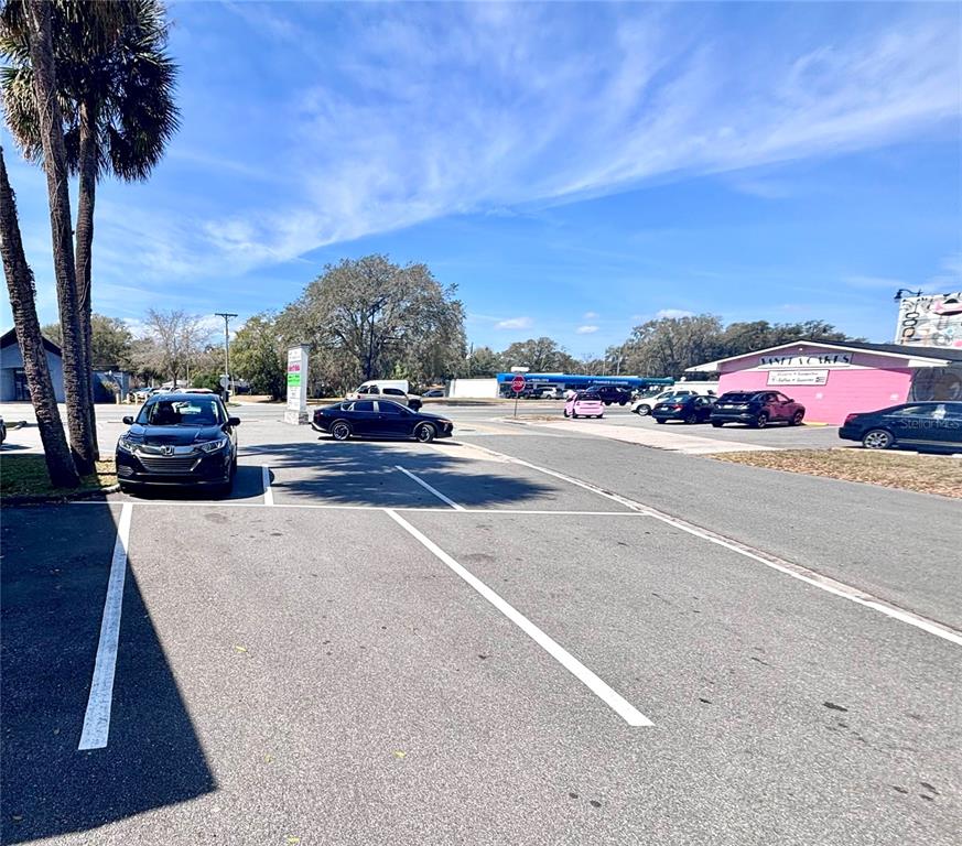 A parking lot sits in front of a pink building under a blue sky — 2201 S FRENCH AVENUE, SANFORD, FL