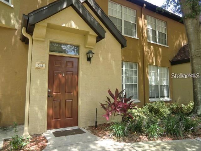 A brown front door with a small porch light sits on a tan stucco building — 6424 RALEIGH STREET UNIT 3112, ORLANDO, FL