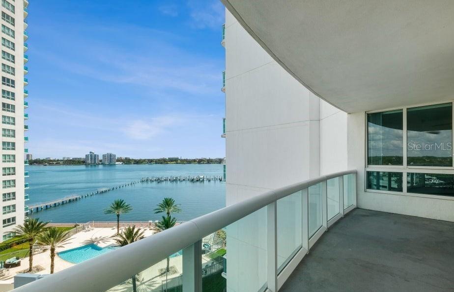 A balcony with a glass railing overlooks a swimming pool and a bay with boats — 231 RIVERSIDE DRIVE UNIT 708-1, HOLLY HILL, FL