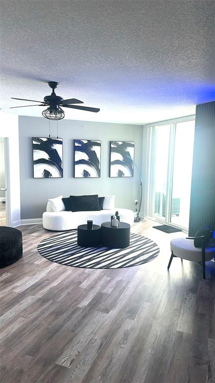 A modern living room features a white sofa, black circular tables, and three abstract paintings — 231 RIVERSIDE DRIVE UNIT 708-1, HOLLY HILL, FL