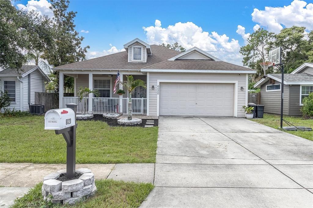 A bright entryway features light blue walls, a wooden console table, a bench, and hardwood floors — 6020 MONTANA AVENUE, NEW PORT RICHEY, FL