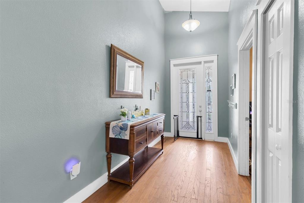 A living room features light blue walls, a white sofa, two armchairs, and a dining area — 6020 MONTANA AVENUE, NEW PORT RICHEY, FL