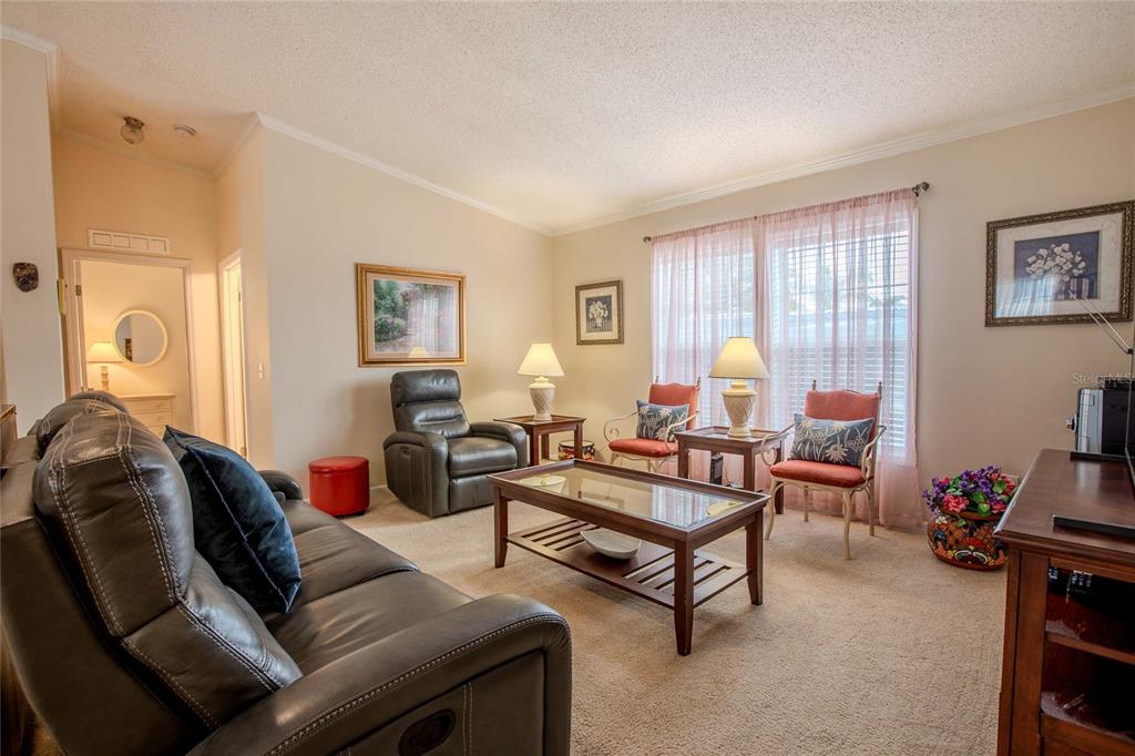 A living room features a leather sofa, a recliner, two accent chairs, and a coffee table — 2100 KINGS HIGHWAY UNIT 690, PORT CHARLOTTE, FL