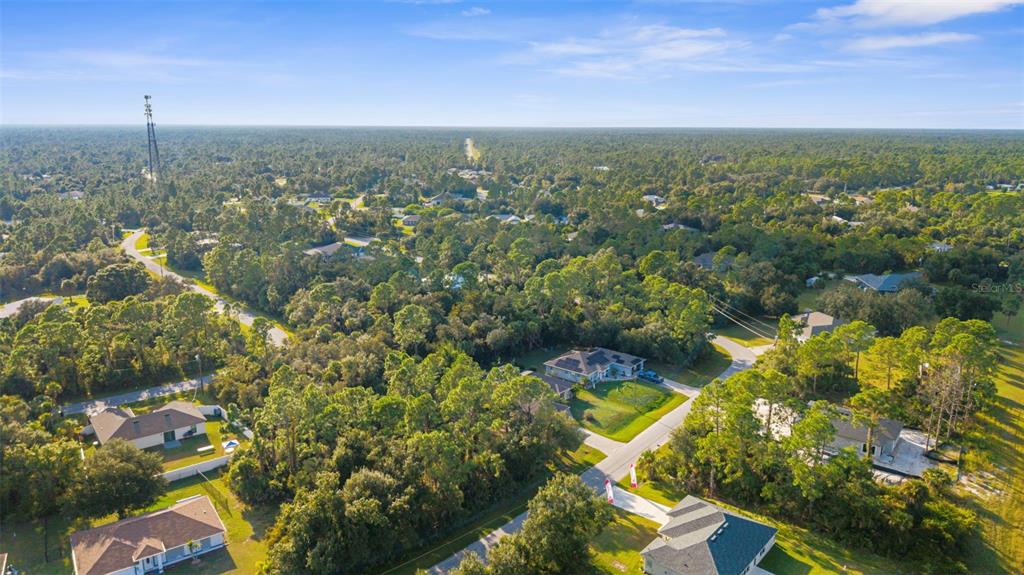 An aerial view shows several houses nestled among dense trees in a suburban neighborhood — 18 BECKWITH AVENUE, NORTH PORT, FL